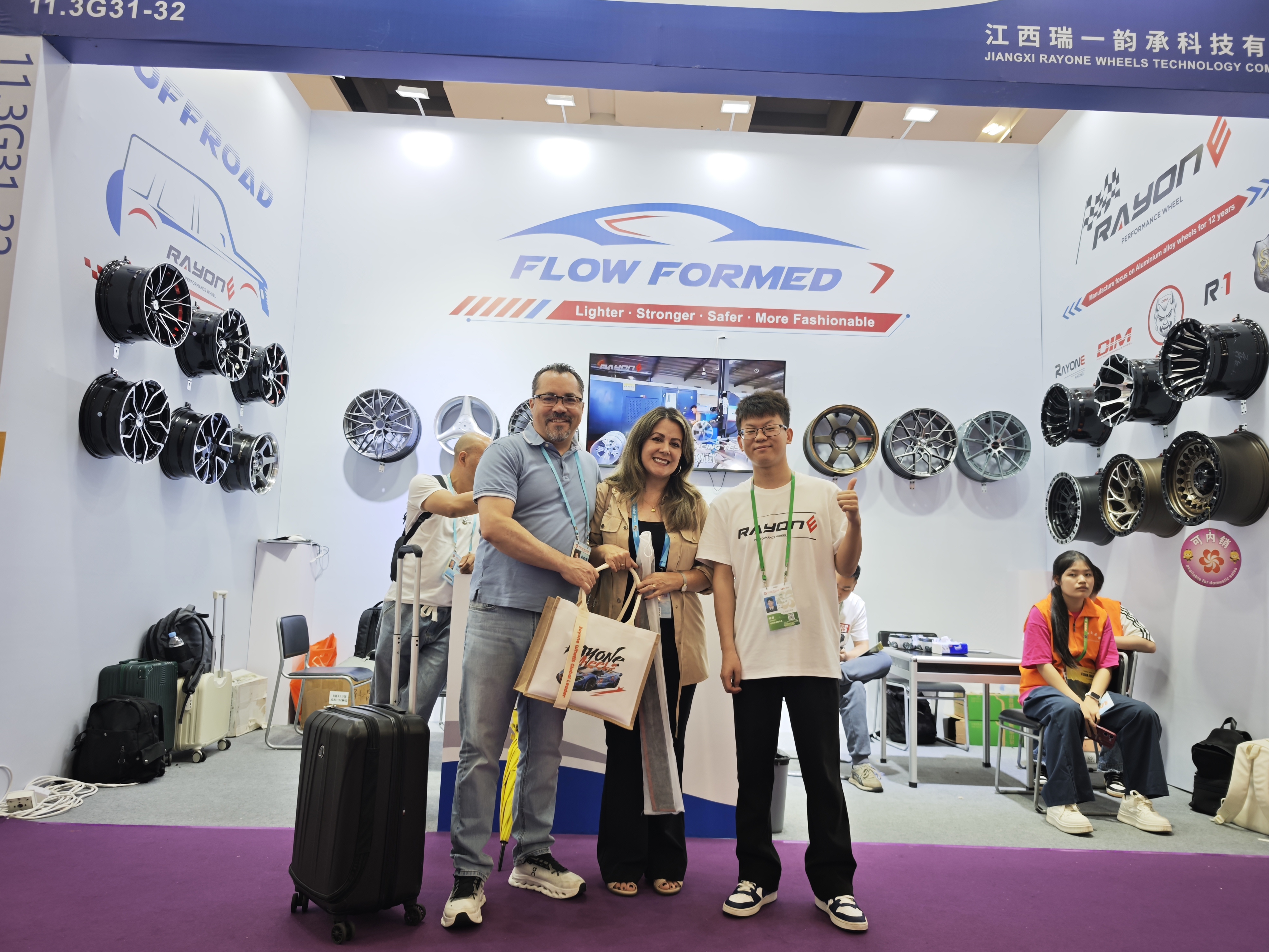 International visitors with the RAYONE team in front of the flow formed wheel display at Booth 11.3G31-32